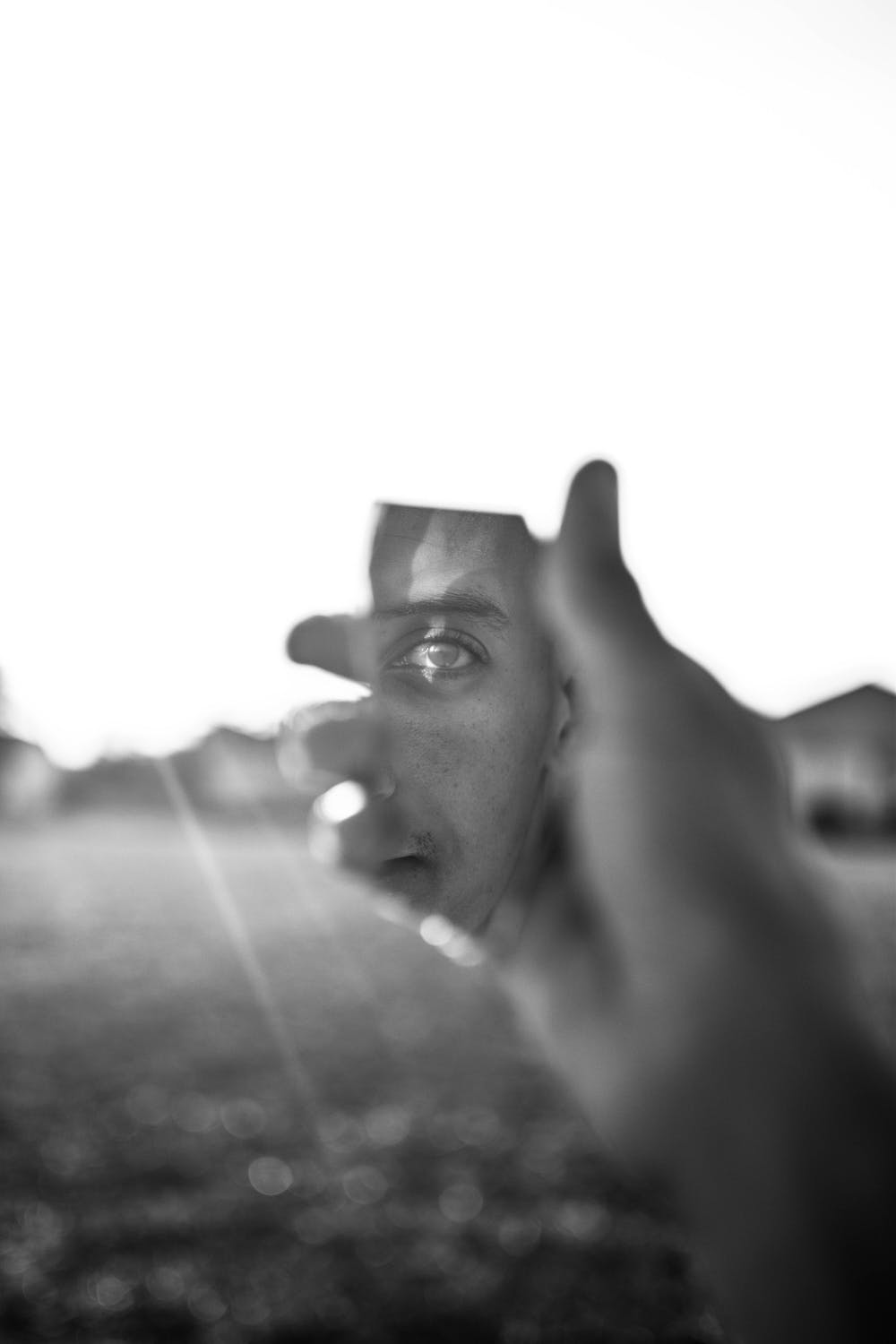 person reflecting in a piece of broken glass.