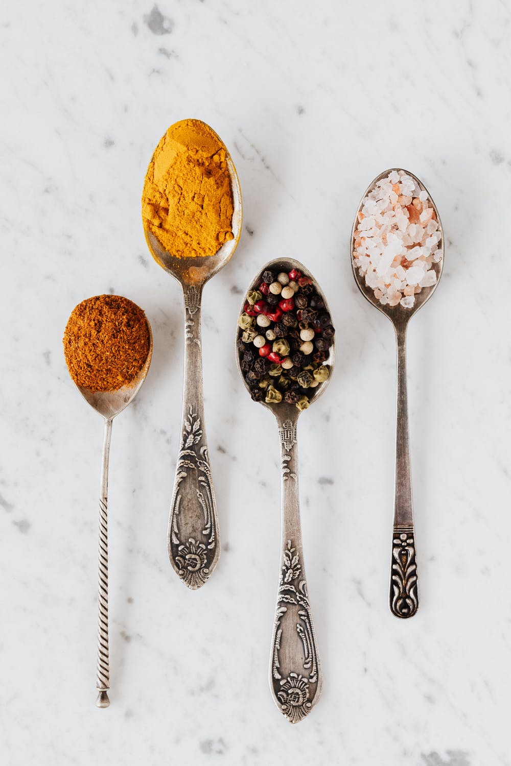 silver teaspoons holding colorful spices