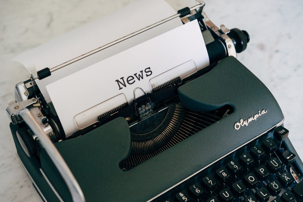 Old-style typewriter with paper in it that says "News"